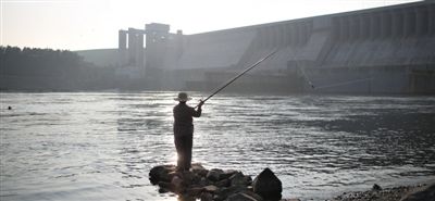 7月6日，湖北丹江口水库大坝下游，老人在江边钓鱼。南水北调中线工程已经进入全线通水倒计时。新京报记者