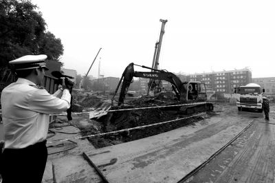 学院南路一科研楼项目有3台挖掘机违规进行土方作业，被城管队员当场责令停工。京华时报记者欧阳晓菲摄